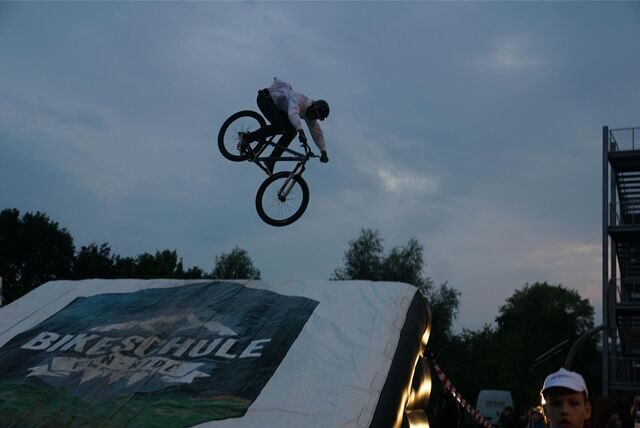 Ein BMX-Fahrer fliegt nach einem Stunt durch die Luft.