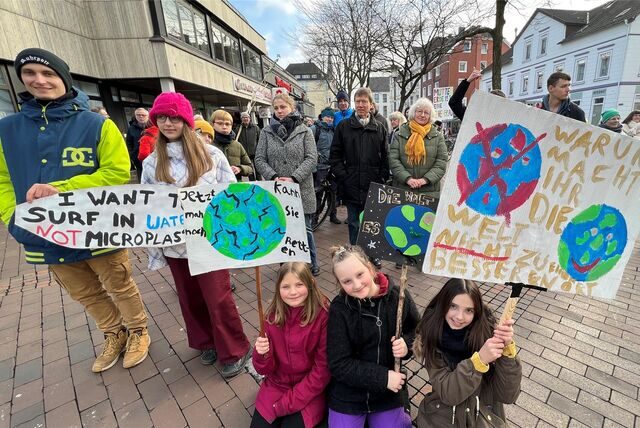 Kinder, Jugendliche und Erwachsene zeigen im März 2023 bunte Schilder und deutliche Botschaften bei einer Klimademo in der Unnaer Innenstadt