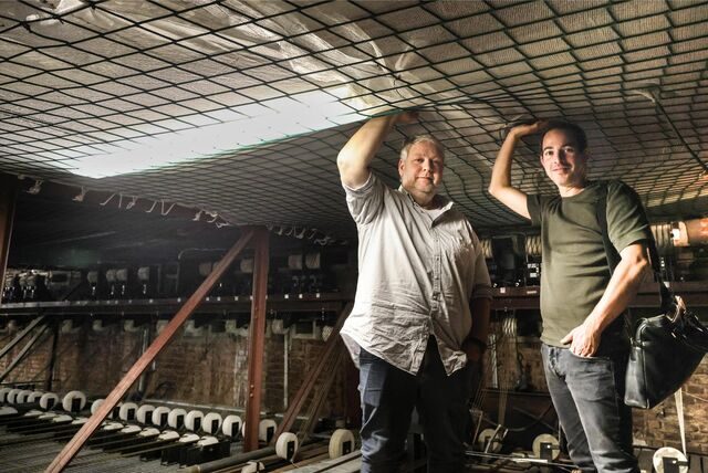Theaterdirektor Tobias Ehinger (r.) und der technische Leiter Thomas Bohl stehen unter dem Dach oberhalb der Bühne. Das Netz soll die Putzbrocken auffangen, die von der Decke fallen.