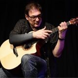 Man sieht den Künstler Don Alder mit einer Gitarre in der Hand.