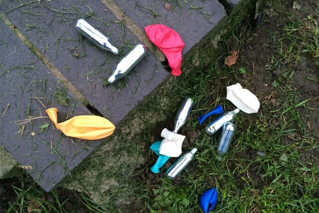 Lachgas-Kartuschen und Luftballons liegen in einem Park. Immer mehr Missbrauchsfälle der Modedroge werden bekannt.