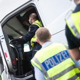 Polizisten kontrollieren einen Lastwagen.
