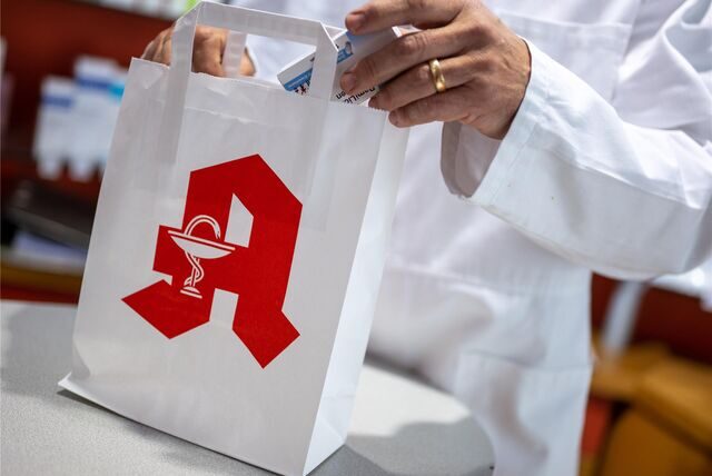 Ein Apotheker packt etwas in eine Tüte