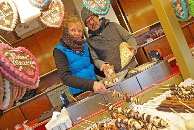 Schausteller Dirk Veenstra mit seiner Frau Elke an seinem Kirmesstand. Er Verkauft unter anderem Lebkuchenherzen, Popcorn und Früchte mit Schoko-Überzug.
