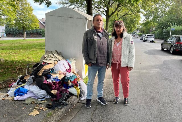 Joachim und Sabine Michels ärgern sich über den Anblick im Umfeld eines Altkleidercontainers an der Straße Auf dem Hohwart