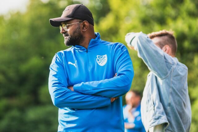 Athavan Varathan schaut mit verschränkten Armen aufs Spielfeld