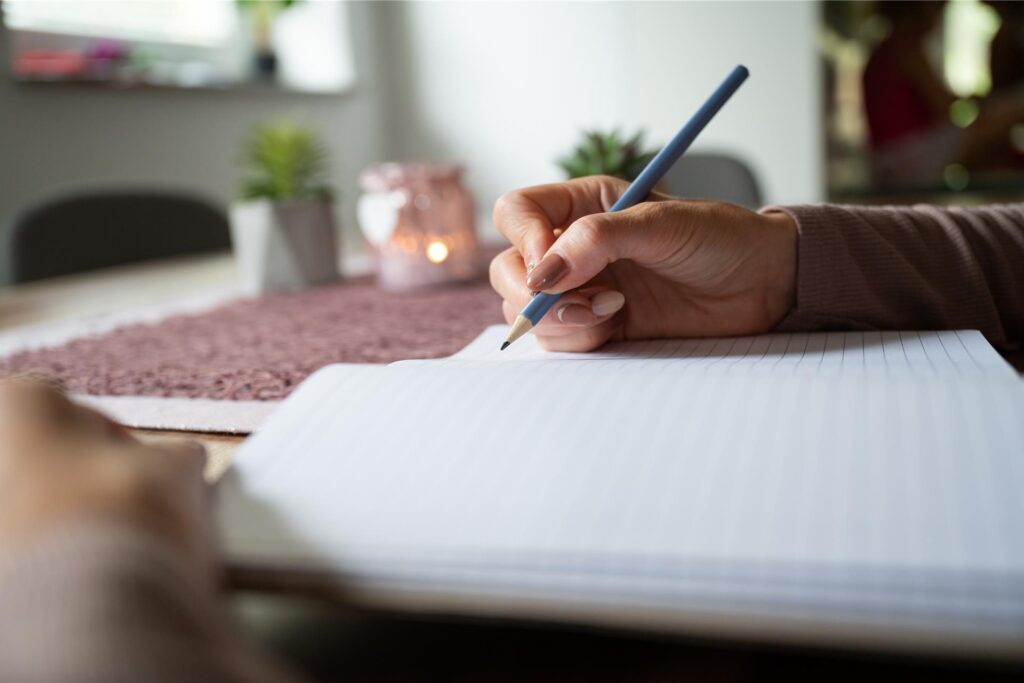 eine hand mit bleistift schreibt in ein heft eine hand mit bleistift schreibt in ein heft
