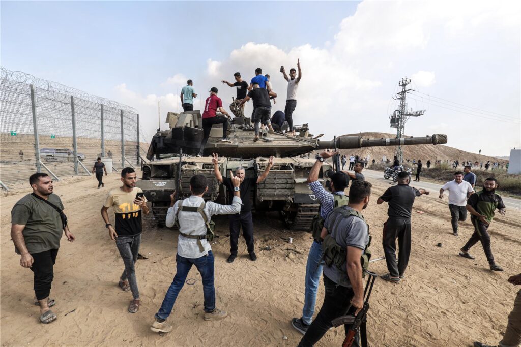 Palästinenser übernehmen die Kontrolle über einen israelischen Panzer, nachdem sie den Grenzzaun zu Israel in Khan Yunis überquert haben.