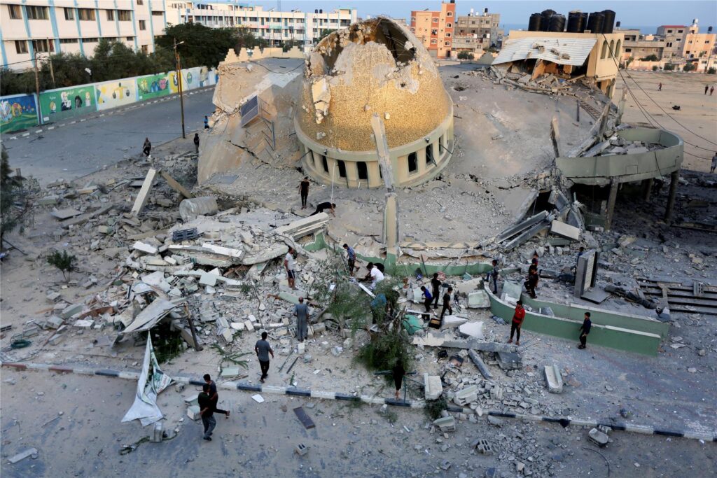 Menschen stehen vor einer Moschee, die bei einem israelischen Luftangriff in Khan Younis im Gazastreifen zerstört wurde.