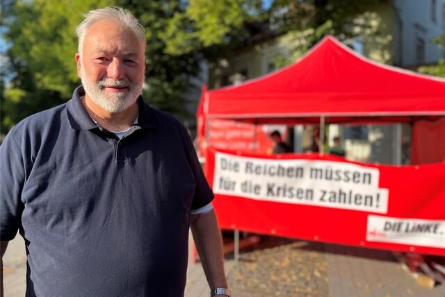 Der Schwerter Linken-Sprecher Peter Weyers steht vor einem Infostand seiner Partei.