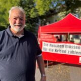 Der Schwerter Linken-Sprecher Peter Weyers steht vor einem Infostand seiner Partei.