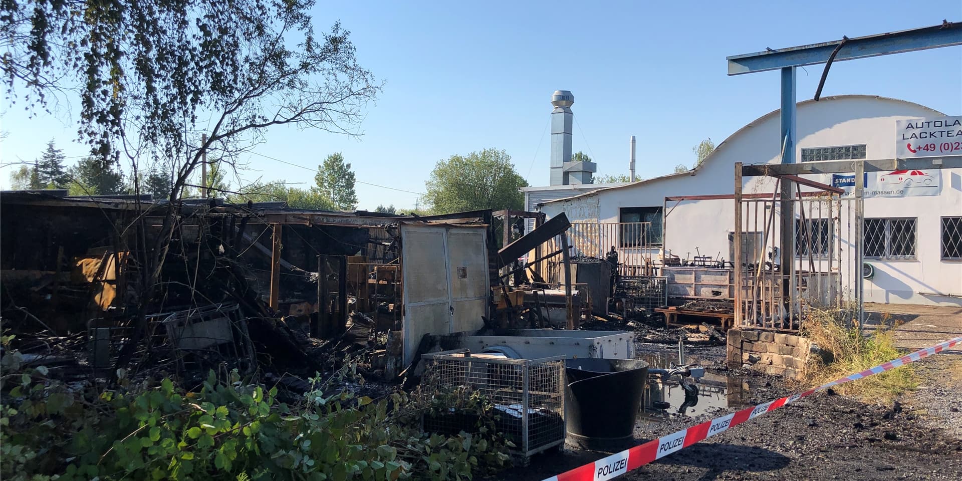 So dicht steht die Lackierwerkstatt an den ausgebrannten Containern, dass Teile der Fassade angekokelt und fast alle Fensterscheiben geplatzt sind. Die Feuerwehr konnte ein Übergreifen der Flammen jedoch verhindern.