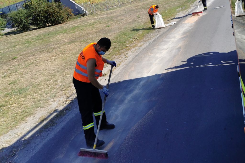 title attribut Auch am Kreisverkehr Lünener Straße/Lippestraße mussten die Einsatzkräfte eine Ölspur aufnehmen. Jeweils in Linkskurven muss das mutmaßliche Verursacherfahrzeug Diesel aus seinem Tank verloren haben. Bei hochsommerlichen Temperaturen wurde die Ölspur abgestreut und das verunreinigte Bindemittel mit Besen und Schaufel wieder aufgenommen.