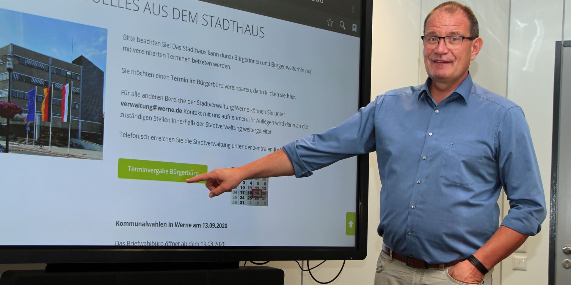 Dezernet Frank Gründken zeigt den Button auf der Homepage der Stadt Werne, mit dem man zur elektronischen Terminvereinbarung gelangt.