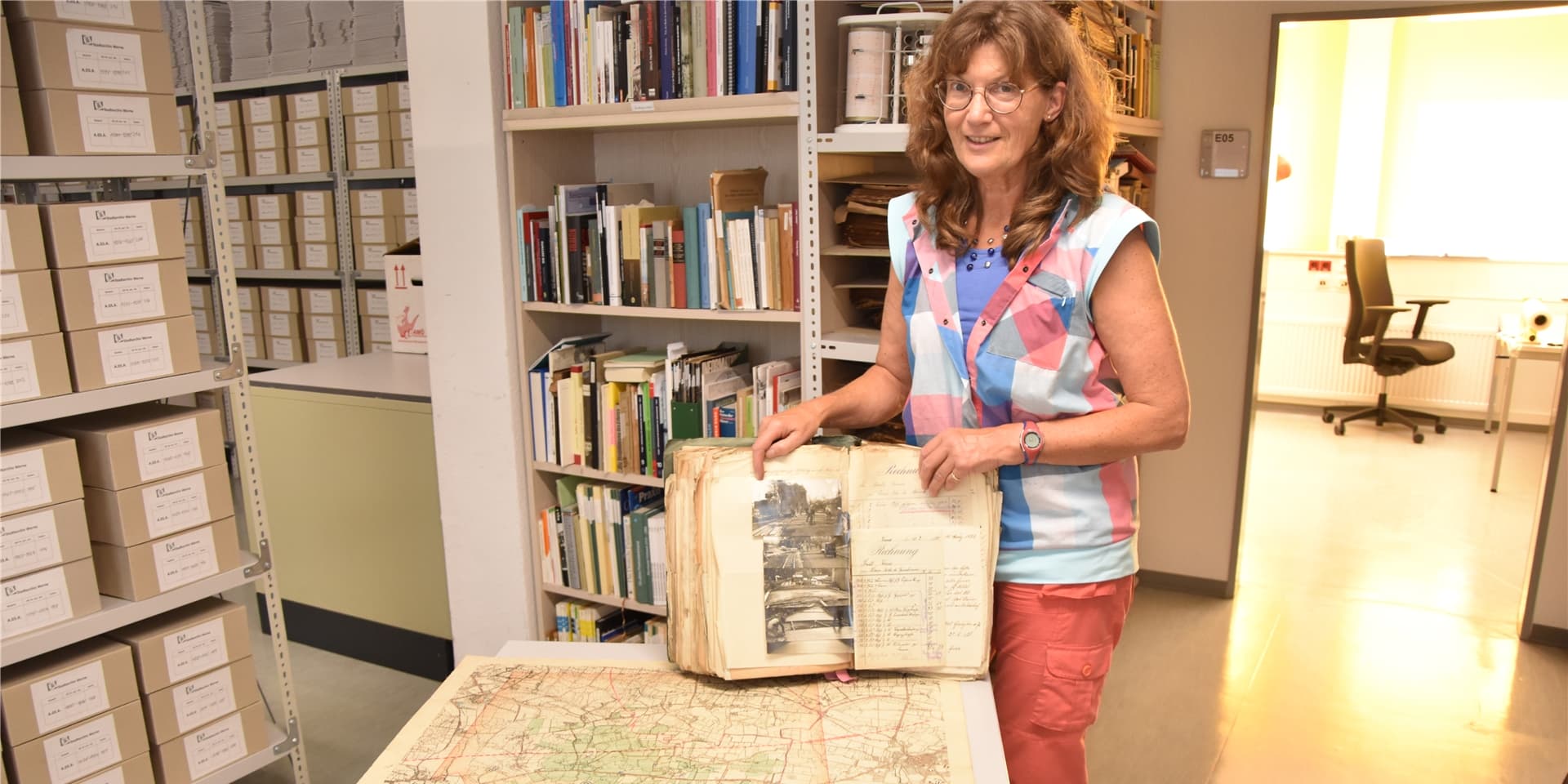 Susanne Maetzke vom Stadtarchiv Werne mit der historischen Straßenbauakte und einer Karte von 1905.