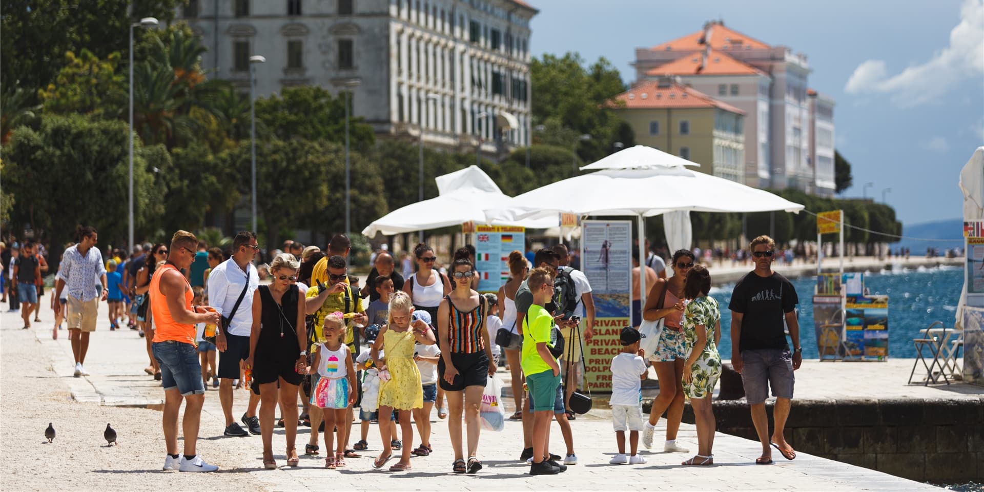 Touristen spazieren an der Uferpromenade von Zadar entlang.