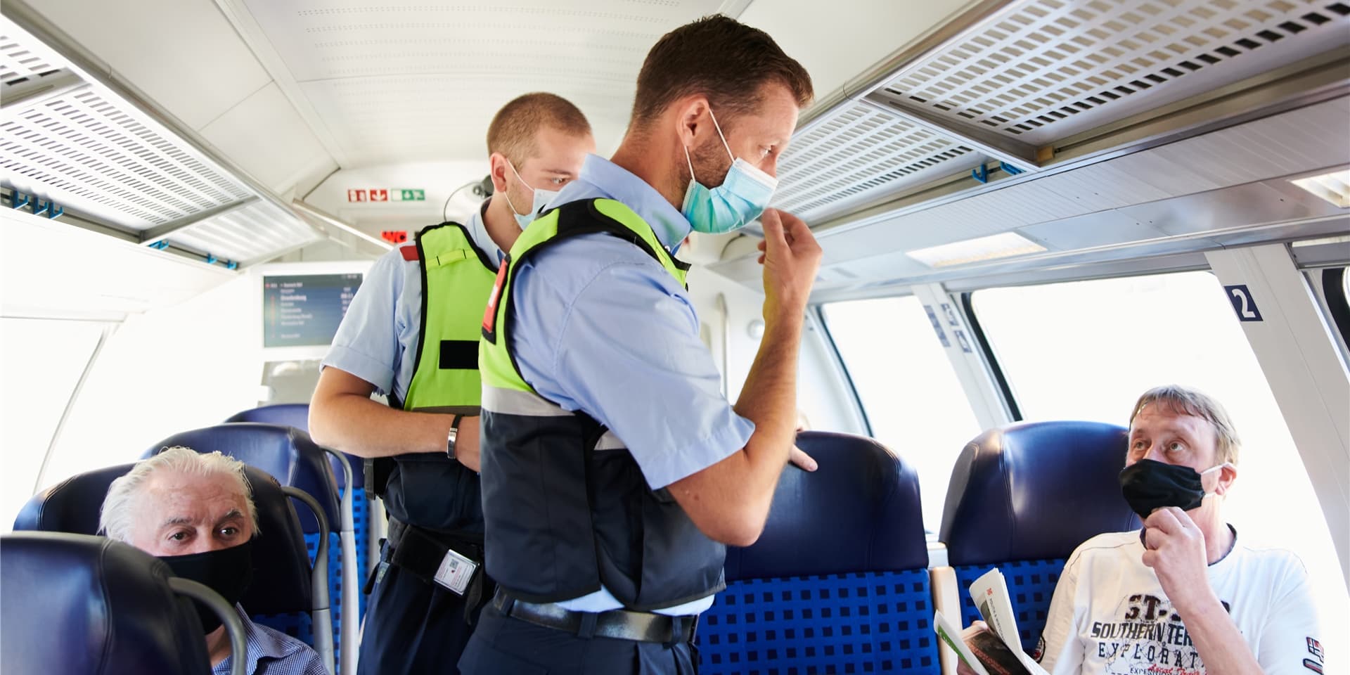 Bundespolizist mit Maske im Gespräch mit Fahrgast mit Maske