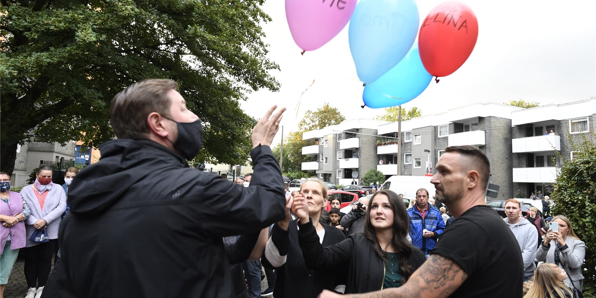 Zusammen mit Oberbürgermeister Tim Kurzbach (l) lassen Nachbarn als Ausdruck ihrer Trauer fünf Luftballons mit den Namen der fünf getöteten Kinder vor dem Haus der Familie steigen.