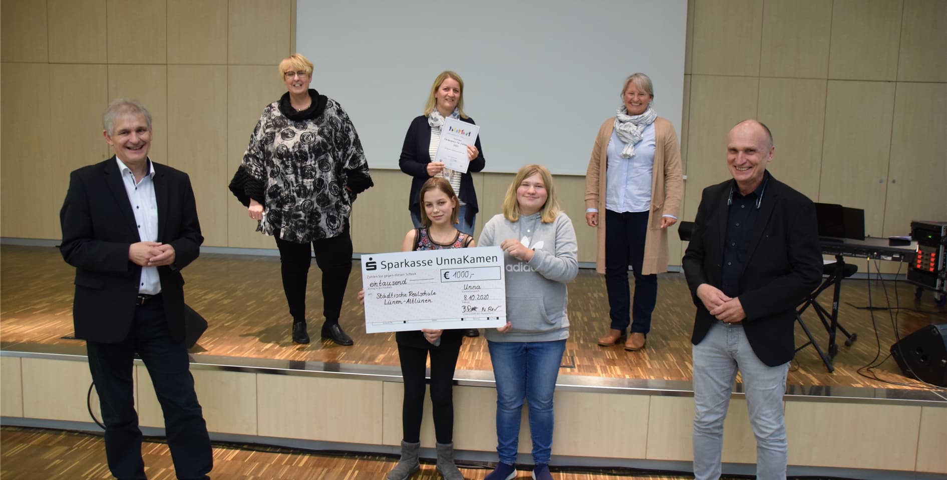 In der Aula des Märkischen Berufskollegs in Unna überreichte Landrat Michael Makiolla (l.) Vertreterinnen der Realschule Altlünen den Förderpreis Inklusion.