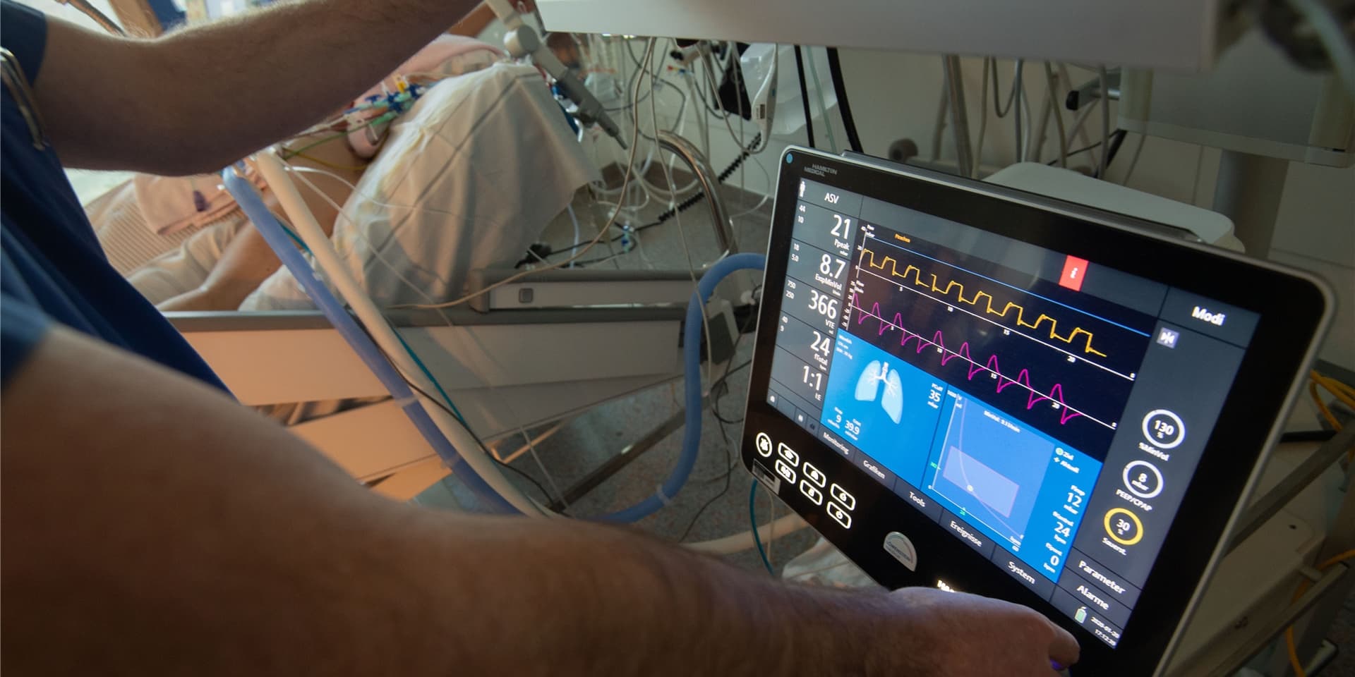 Ein Arzt bedient eine Beatmungsmaschine auf einer Intensivstation.