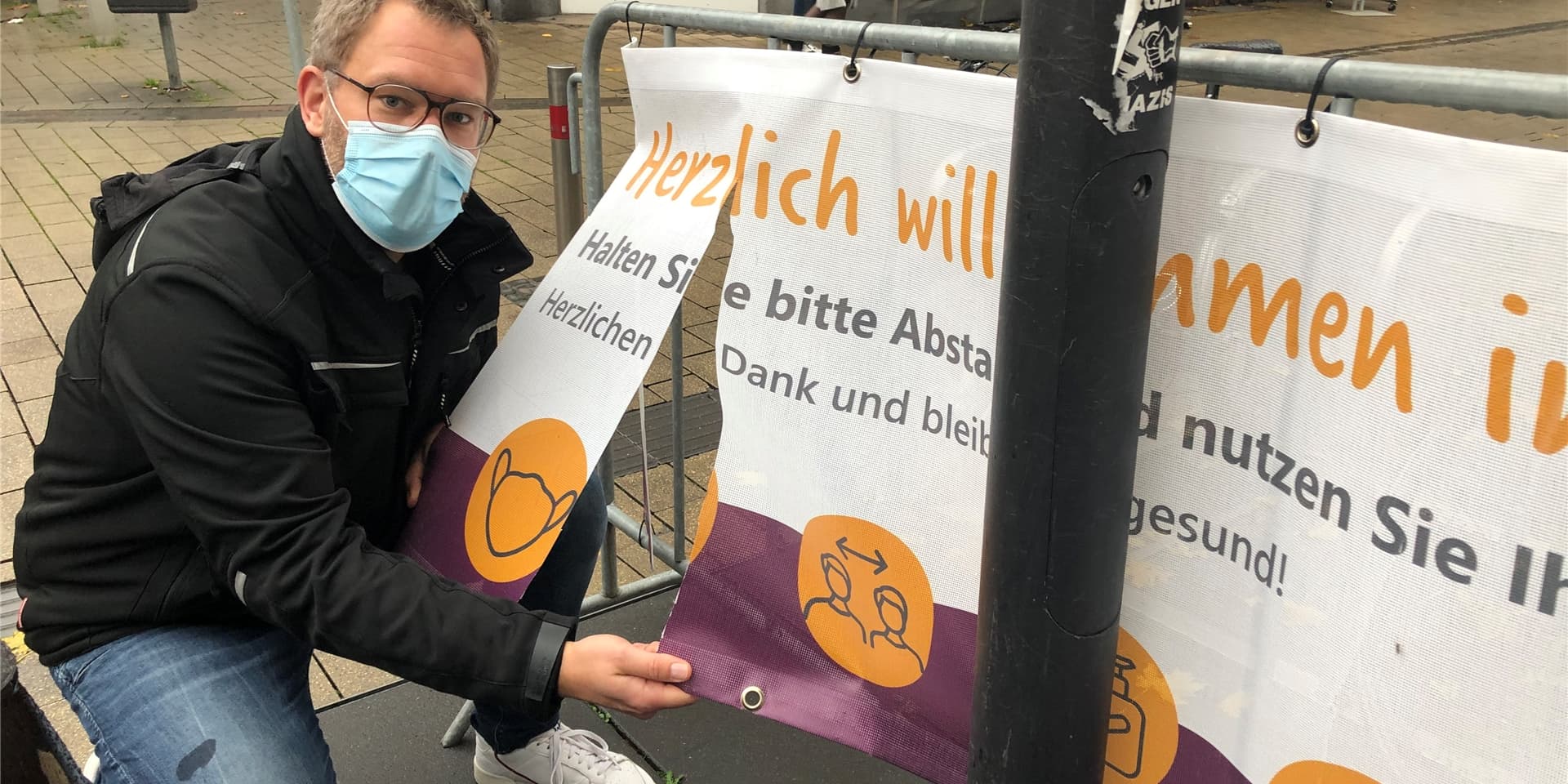 David Ruschenbaum vom Stadtmarketing zeigt eines der drei zerschnittenen Banner in Werne.