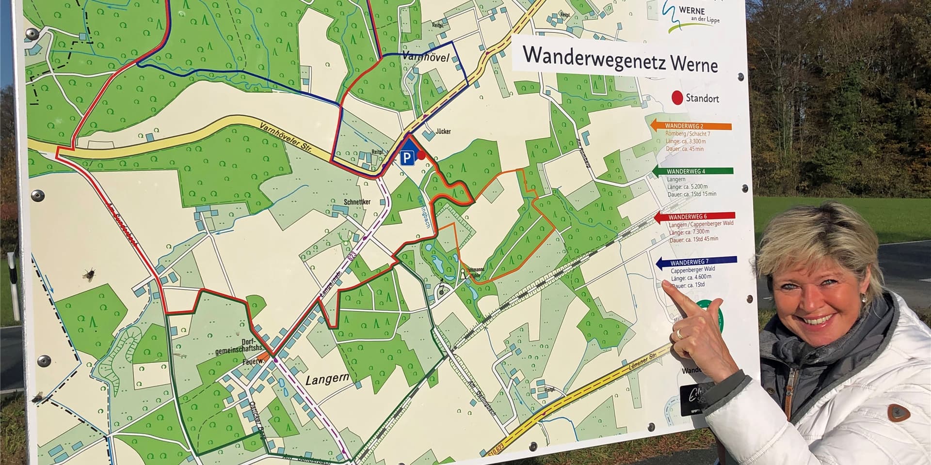 Wanderfreundin Debra Weiser (60) zeigt am Ausgangspunkt, dem Wanderparkplatz an der Varnhöveler Straße, auf die Route des W7.