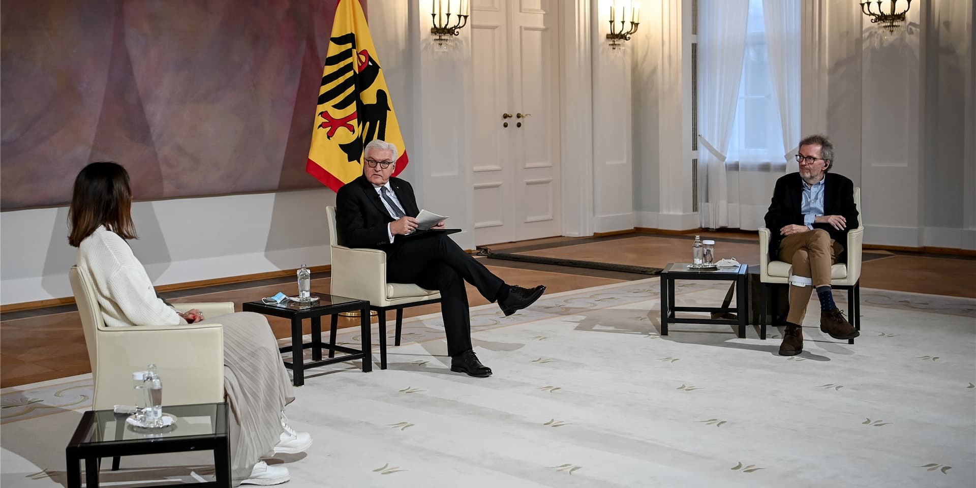 Bundespräsident Frank-Walter Steinmeier spricht mit den Covid-19-Genesenen Nadja Alzner (l), Projekt- und Eventmanagerin, Yoga-Lehrerin und Coach, und Joachim Huber (r), Journalist.