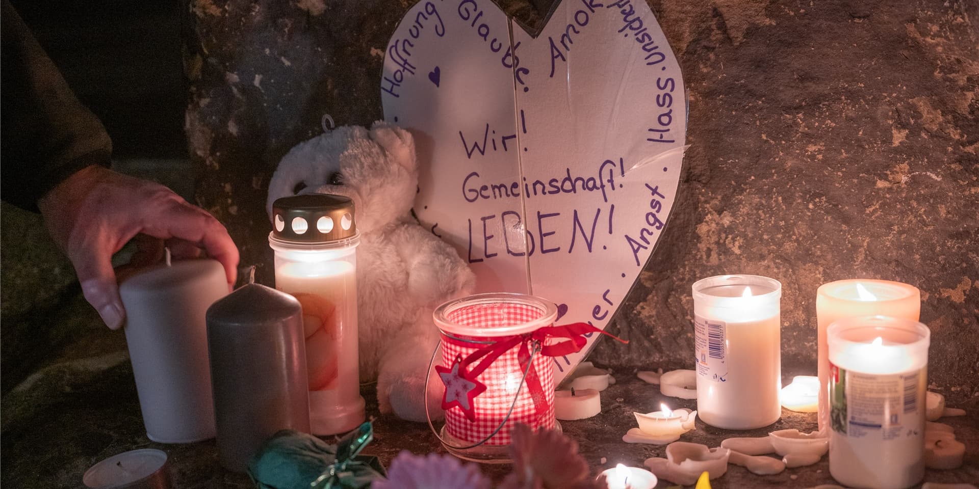 Ein Mann zündet an der Porta Nigra eine Kerze für die Opfer einer Amokfahrt eines 51-jährigen Mannes durch die Trierer Innenstadt an.