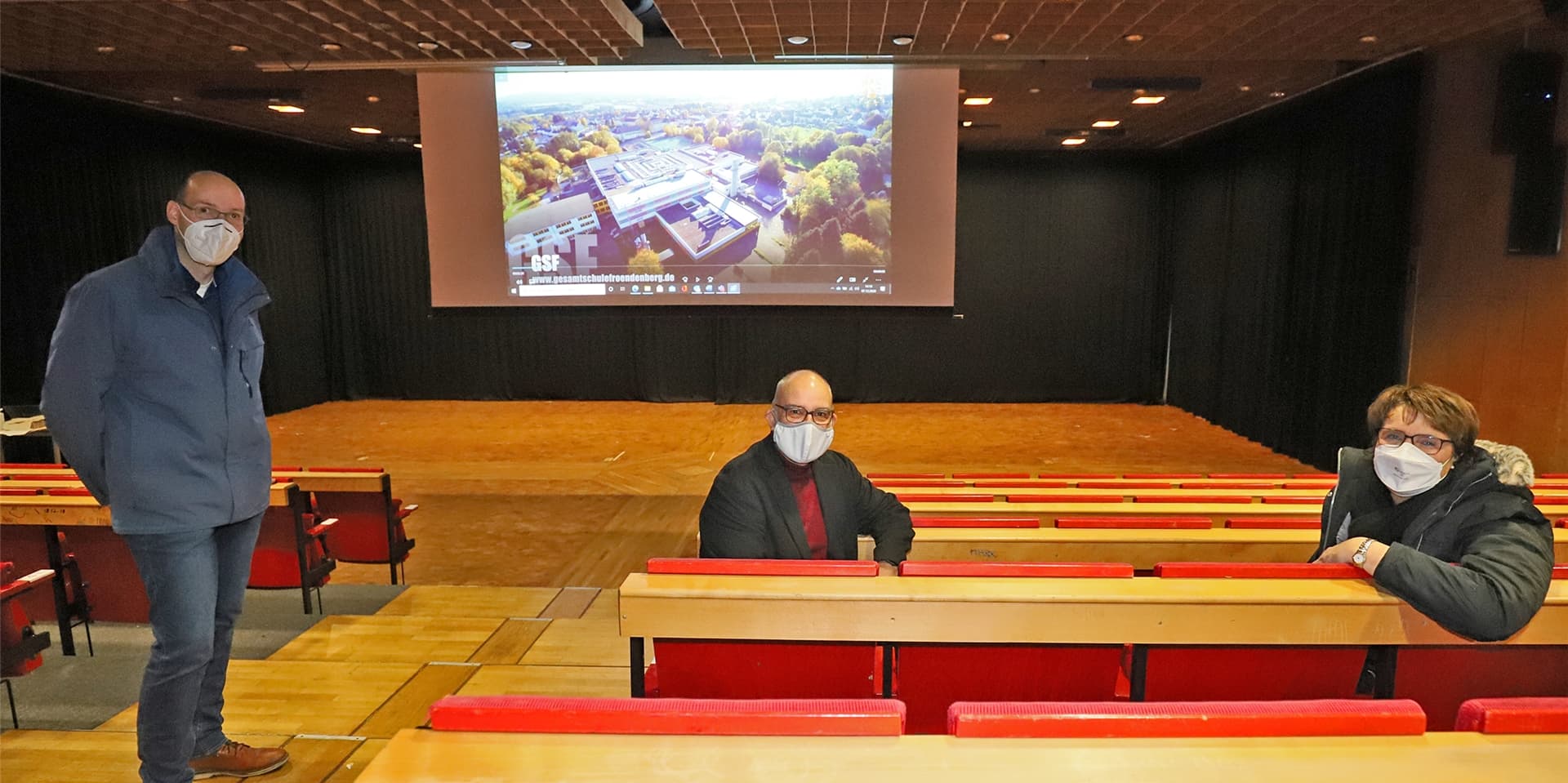 Ole Strathoff, Stadt Fröndenberg, Schulleiter Klaus de Vries und Bürgermeisterin Sabina Müller (von links) zeigen den neuen Imagefilm der Gesamtschule Fröndenberg.