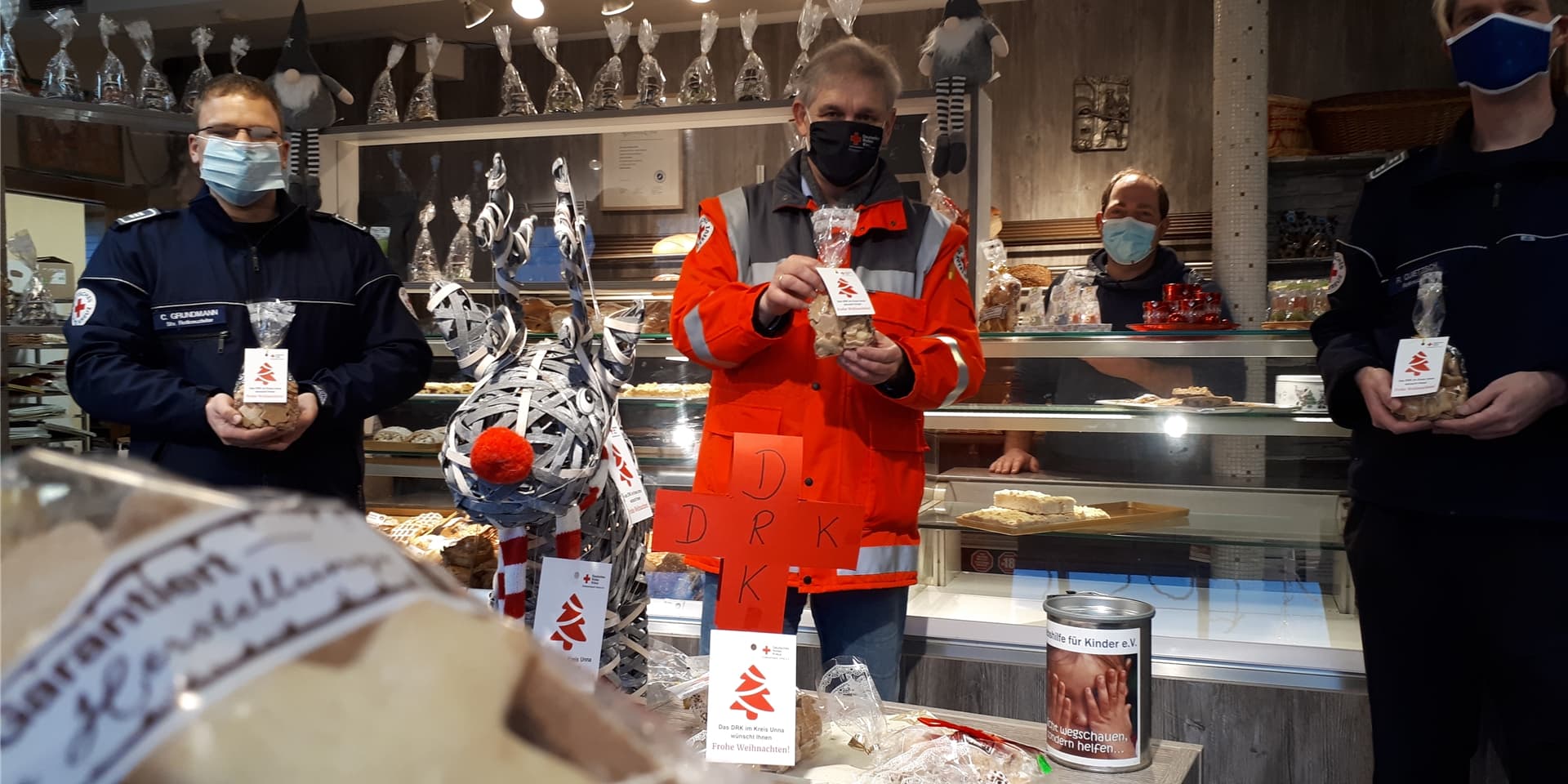 Christopher Grundmann, Michael Makiolla und Ralf Quietzsch (von links) zusammen mit Bäcker Jens Klein (hinten) und den Rotkreuzchen-Keksen in der Bäckerei Klein in Warmen.