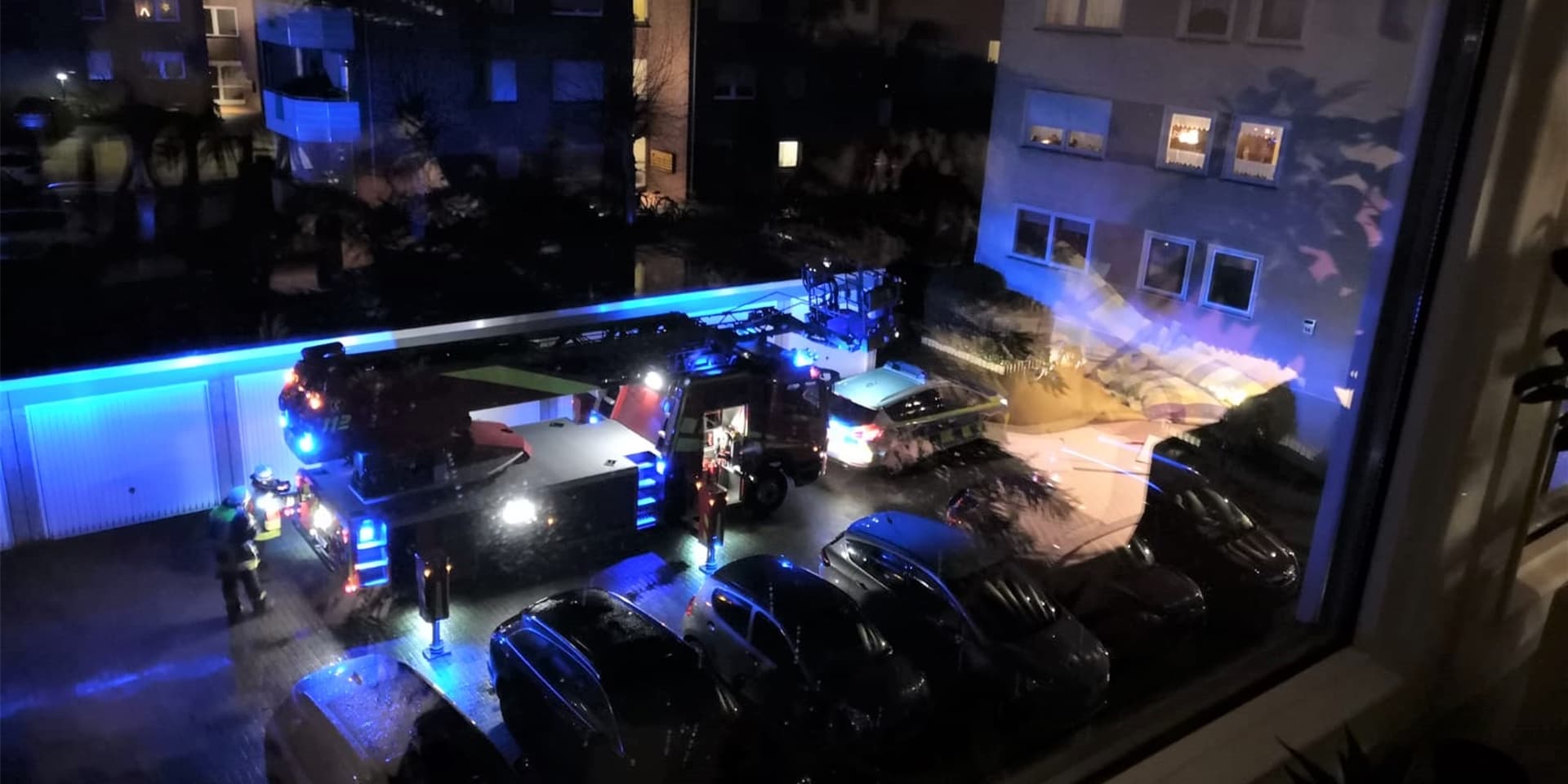 Die Drehleiter der Feuerwehr steht im Garagenhof des Holtkamp-Hochhauses. Dort war ein Bewohner aus bisher ungeklärten Gründen in seiner Wohnung gestorben.