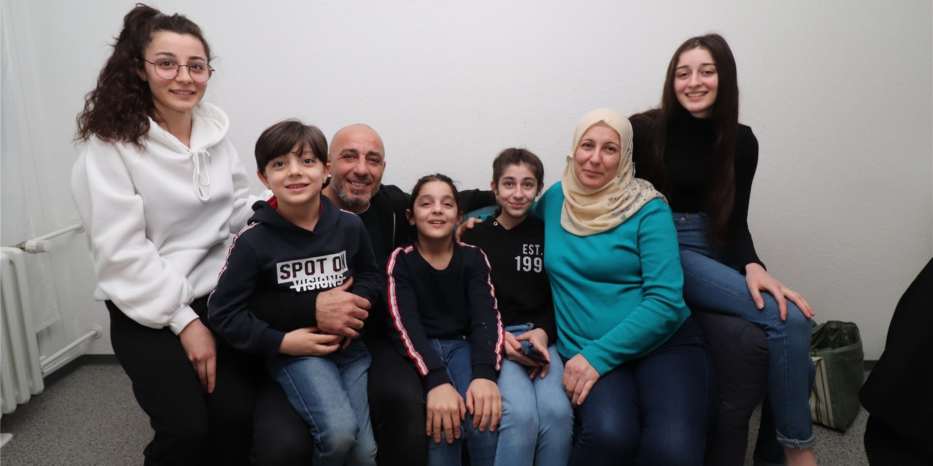 Sie sind eine glückliche Familie – und rücken in ihrer kleinen Wohnung eng zusammen: Nada (19), Ahmed (6), Abdulkader (47), Mohammad (11), Elaf (13), Fawzia (46) und Sara (17) Ismail.