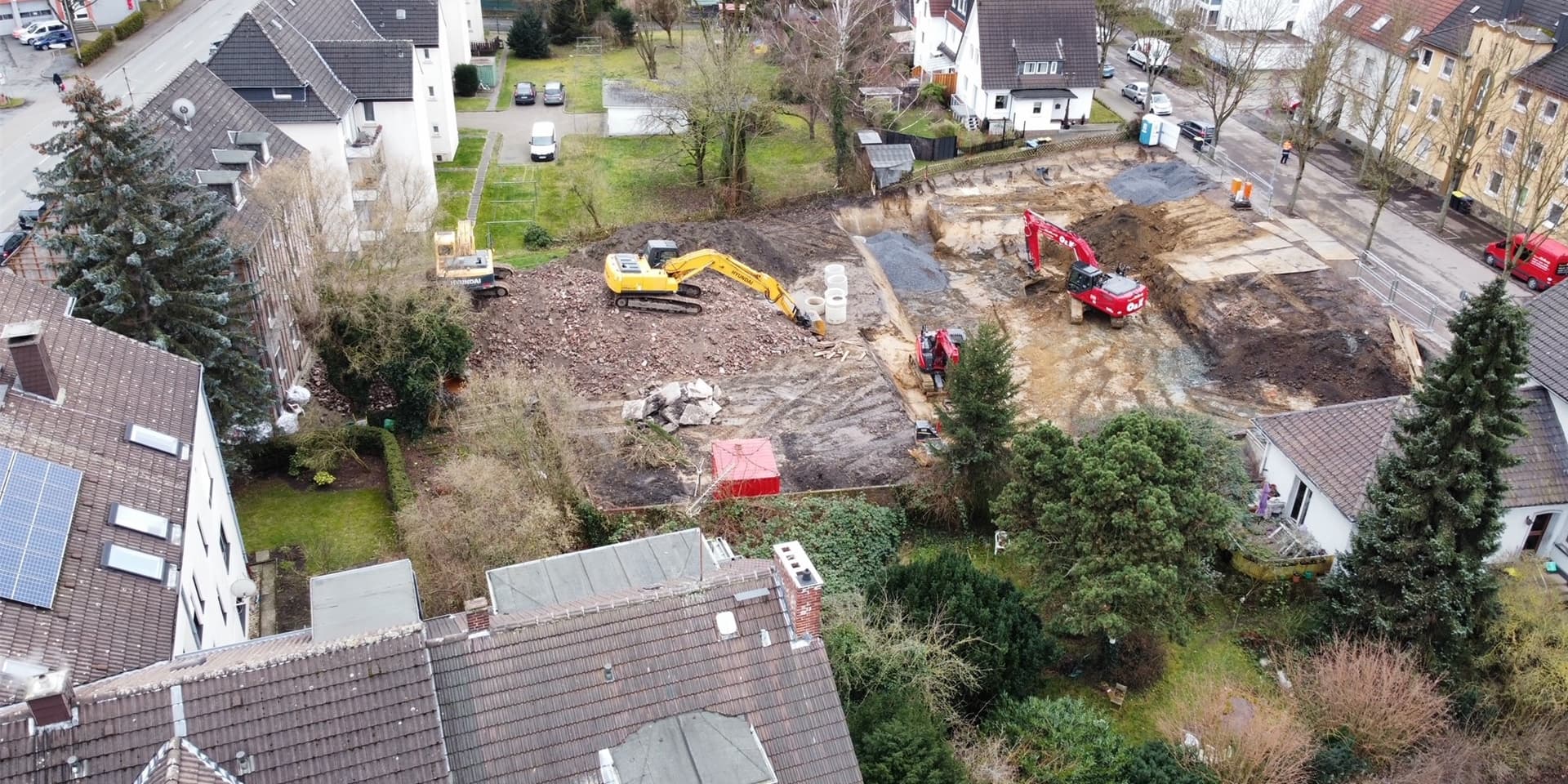 Ein Luftbild zeigt die Tiefbauarbeiten an der Hermannstraße. Wenn das benachbarte Gebäude an der Lohbachstraße (links hinter der großen Tanne) abgerissen ist, soll hier ein neues Wohnquartier entstehen.