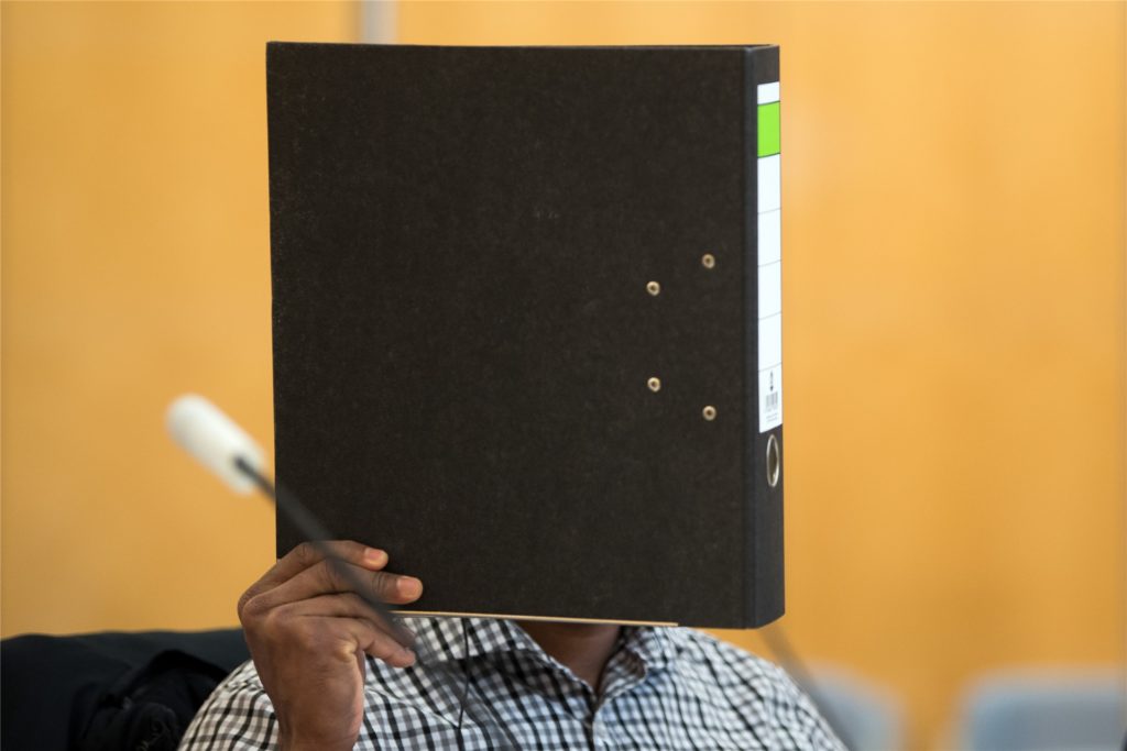 title attribut Der 27-Jährige aus Werne, hier hinter einem Aktenordner, war wegen sechsfachen Mordes angeklagt und soll als 15-Jähriger in Sri Lanka vor einem Konvoi der sri-lankischen Armee eine Bombe ferngezündet haben. Wahrscheinlich eine Lüge, wie sich im Prozess herausstellte.