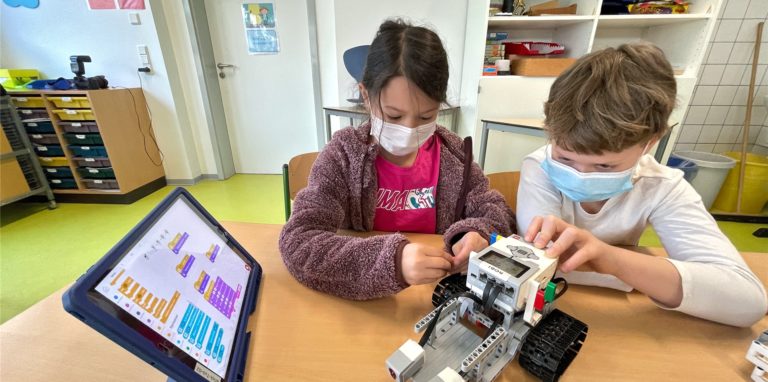 Maja und Lasse haben ihren Roboter in der Ferienschule in Holzwickede so programmiert, dass er mit seinen Sensoren Farben erkennen und entsprechende Symbole auf dem Display anzeigen kann.