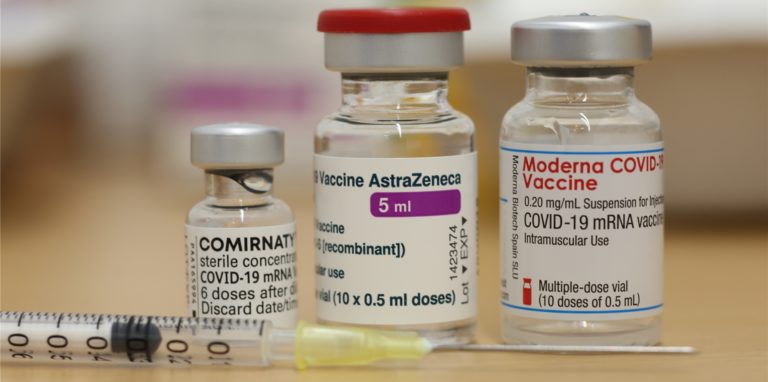 Ampullen mit dem Impfstoff von Biontech Comirnaty , AstraZeneca und Moderna stehen auf einem Tisch – Diese drei Corona-Impfstoffe sind derzeit in Deutschland im Einsatz.