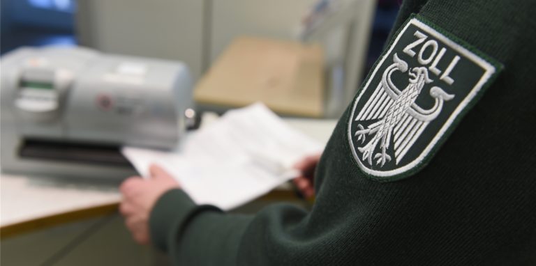 Ein Zollbeamter stempelt einen Ausfuhrzettel ab.