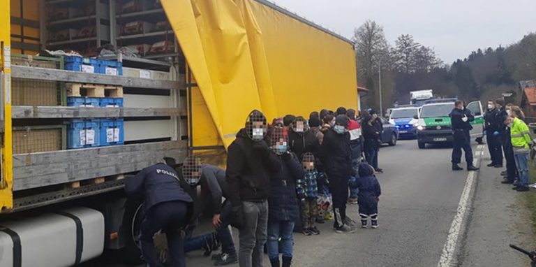 27 geschleuste Menschen stehen vor der Ladefläche eines Lkw. Wegen solcher Szenen hat es auch in Dortmund eine Hausdurchsuchung gegeben.