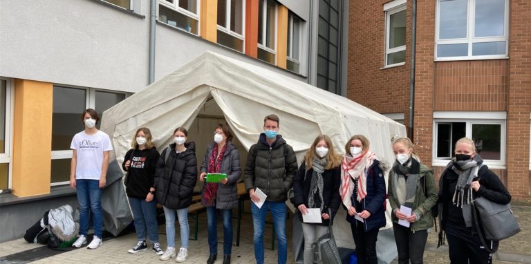 Die Abiturienten des RTG mit Schulleiterin Bärbel Eschmann auf dem Schulhof vor dem DRK-Testzelt.