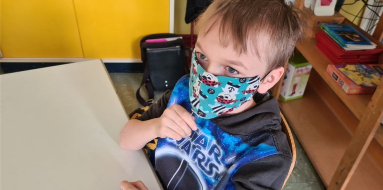 Dominik schiebt das Teststäbchen unter der Maske hindurch in den Mund. 30 Sekunden müssen seine Klassenkameraden und er auf dem Stäbchen lutschen, ehe es von den Lehrkräften eingesammelt wird.