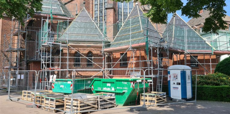 Ein Baugerüst hüllt die Türme an der St.-Marien-Kirche in Lünen ein. Die Dächer erhalten eine neue Schieferabdeckung.