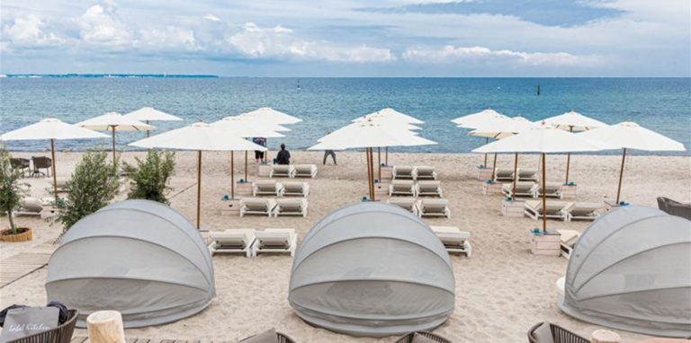 Strandliegen und Sonnenschirme stehen in Timmendorfer-Strand für Badegäste bereit.