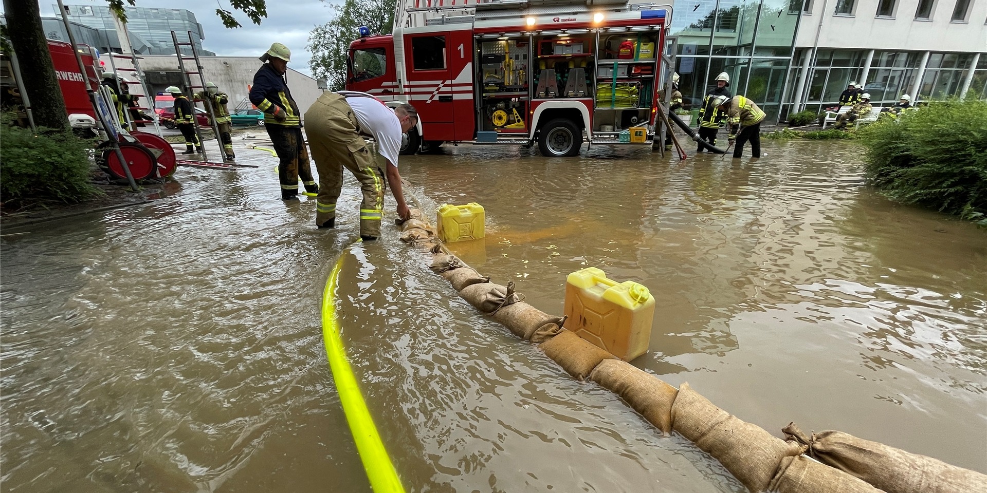 Die Regenmassen und Wasserfluten versuchten Feuerwehrleute am Sonntag mit Barrieren aus Sandsäcken vom Haus Löhnbachtal fernzuhalten.