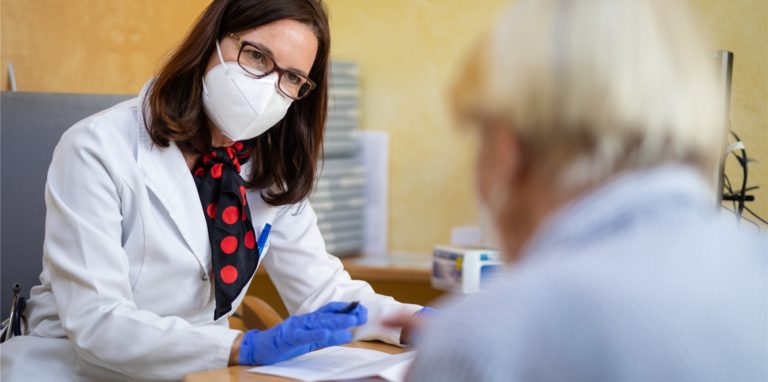 Eine Fachärztin für Allgemeinmedizin, spricht in ihrer Praxis mit einer Patientin, die wenig später ihre zweite Corona-Impfung erhält.