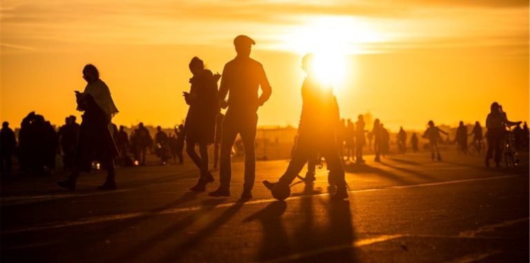 Menschen spazieren während des Sonnenuntergangs bei frühlingshaften Temperaturen auf dem Tempelhofer Feld in Berlin.
