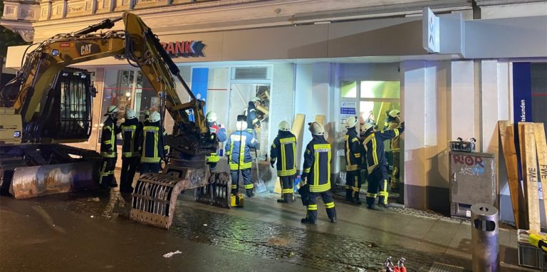 Feuerwehrleute stehen vor einem Haus, in dem mehere Geschossdecken eingesackt sind.