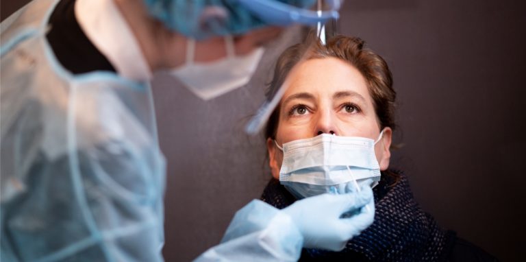 Eine Frau lässt sich in einem Corona-Schnelltest-Zentrum mit einem Nasenabstrich auf das Coronavirus testen.