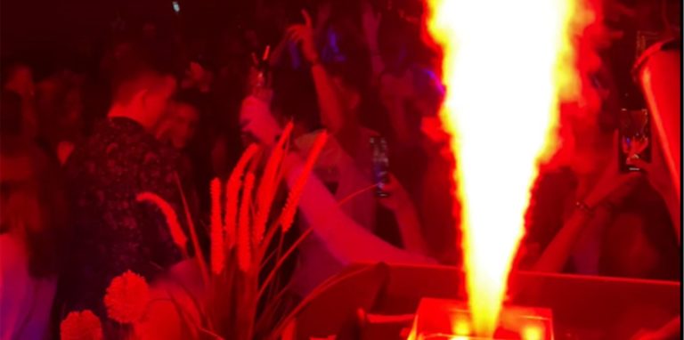 Tanzende Menge in dunklem, rot beleuchteten Nachtclub