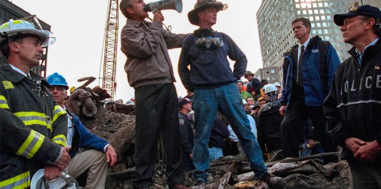 US-Präsident George W. Bush (M,l), spricht in den Trümmern des New Yorker World Trade Centers neben dem pensionierten New Yorker Feuerwehrmann Bob Beckwith zu den freiwilligen Helfern und Feuerwehrleuten durch ein Megafon.