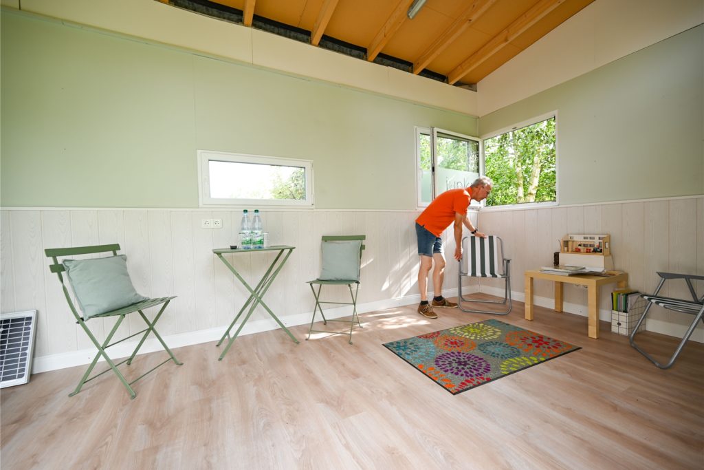 title attribut Uwe Christof steht in seinem Tiny House, das in seinem Schrebergarten steht.